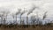 The field with the died and dried-up flowers against the background of large oil refinery. Dramatic sky background