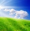 Field of green grass and blue cloudy sky