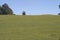 Field on green grass with blue sky in the background without people or a tree in Chile