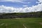 A field with green grass in front of the Inca ruins Saqsaywaman near Cusco.