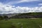 A field with green grass in front of the Inca ruins Saqsaywaman near Cusco.