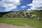 A field with green grass in front of the Inca ruins Saqsaywaman near Cusco.