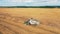 A field with a harvester cutting wheat while riding