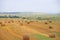 Field with haystacks. Russian open spaces. Dry grass twisted into stacks