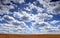 Field with hewed corn and clouds