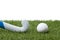 Field hockey stick and ball on the green field. Professional sport concept