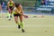 Field hockey woman player passes the ball