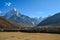 Field looking over a stone fence and the Himalayan mountains