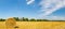 A field with lots of straw bales, with a blue sky