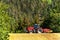 Field and operation of the tractor. Wind and dust over workers. Red tractor on a field. Agricultural landscape in the Czech Republ