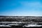 A field partially covered with snow on a hill