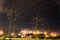 Field with power lines and illuminated streetlights at night - industry