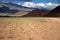 A field road running through desert steppe landscapes at the foot of high hills