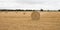 field with Round bales of straw boots