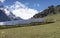 Field with rows of blue solar panels in grassland with snow peak background in Jammu-Kashmir,India