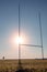 Field with tall goal posts for Irish National sports on green grass against clear blue sky and the sun. Rugby, hurling, camogie