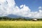 Field in Thailand with bamboo building and big sky