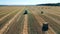 Field with a tractor and multiple piles of hay