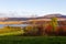 Field and trees in the Fall, with the St. Lawrence River and the Laurentian mountains in soft focus background