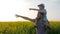 Field walk of dad and son in sunny weather, men with little boy go by field and point hand to horizon,