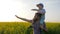 Field walk of daddy and kid in sunny weather, son on father`s shoulders in blossom, meadow flowers and child with dad