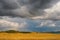 Fields and open spaces in the steppes of Tuva against the background of sunset clouds in autumn