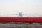 Fields with rows of red tulips in springtime for agriculture of flowerbulb on island Goeree-Overflakkee in the Netherlands, watere