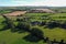 fields and trees near a small farm in Ireland in summer, top view. Irish agrarian landscape, nature. Green grass field