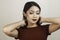 A fierce-looking Asian woman in a red shirt posing in front of white background