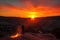 fiery canyon sunset, with a silhouetted person standing on the rim of the canyon