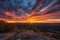 fiery canyon sunset, with view of distant city skyline, and clouds in the sky