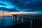 Fiery cloud and sky over the sea at sunset with a pier