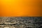 Fiery horizon, dramatic ocean sunset in vibrant hues over dark waters,