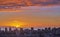 A fiery red sunset cityscape and beach with sunset sky in evening. Birds eye view of a city and colorful sky with clouds