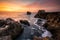 Fiery sunrise sky at a rocky coastline