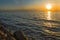 Fiery sunset above the sea with shore stones