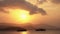 A fiery sunset on the shore of a tropical island. Fishing boats stand in the bay against the background of mountain silhouettes