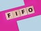 FIFO First in, first out word on wooden cubes on blue. Accounting Concept