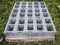 Fifteen Concrete blocks on a wooden palate secured with plastic sitting on grass ready for DIY project