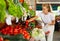 Fifteen-year-old girl shopper chooses fresh tomatoes