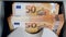 Fifty-euro bills are being processed by counting equipment