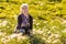 Fifty-year-old blonde woman sitting in the grass in summer