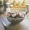 Fig halves in sieve on grey kitchen table with knife and kitchen utensils in background. Preparing healthy Mediterranean fruit at