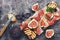 Fig with ham, cheese and toast. Prosciutto with figs on a rustic background. Top view, overhead, flat lay.