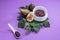 Fig jam with figs, fig leaves and white spoon with jam on purple background