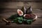 Fig jam with figs, fig leaves and wooden spoon with jam on wooden background