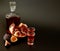 Fig pomegranate liqueur, homemade alcohol with two glasses and a bottle on a black background, next to ripe fruits