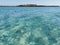 Fig Tree Bay beach, crystal clear water, white sand at the bottom, small island off the coast