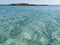 Fig Tree Bay beach, crystal clear water, white sand at the bottom, small island off the coast