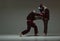 Fighter attacking guy during mixed fight. Males wearing kimono and boxing gloves training martial art technique